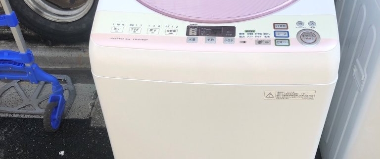 SHARP製全自動洗濯機 ES-GV80P-P を屋外で撮影した外観写真。上部にはピンクの透明蓋があり、清潔感のある白いボディが特徴。